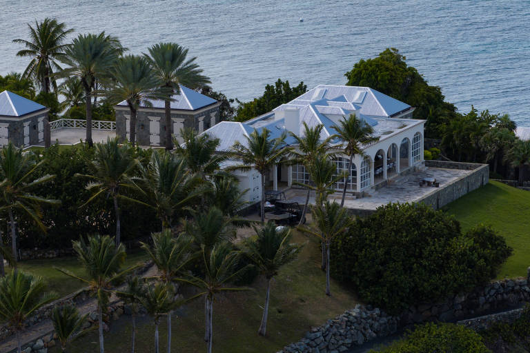 Foto interna de um banheiro amplo e moderno na mansão de Epstein, com azulejos brancos e amenidades de luxo