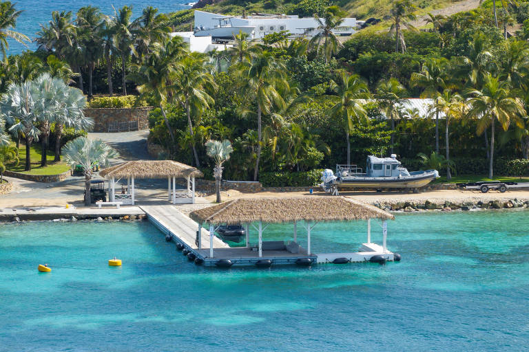 Vista externa da ilha de Little Saint James, com vegetação tropical e estruturas de luxo à beira-mar