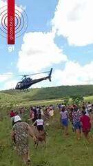 Helicóptero jogando pacotes de carne sobre a multidão em Aparecida de Goiânia