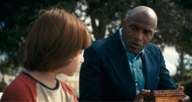 Pennywise emergindo das sombras em uma cena tensa da série